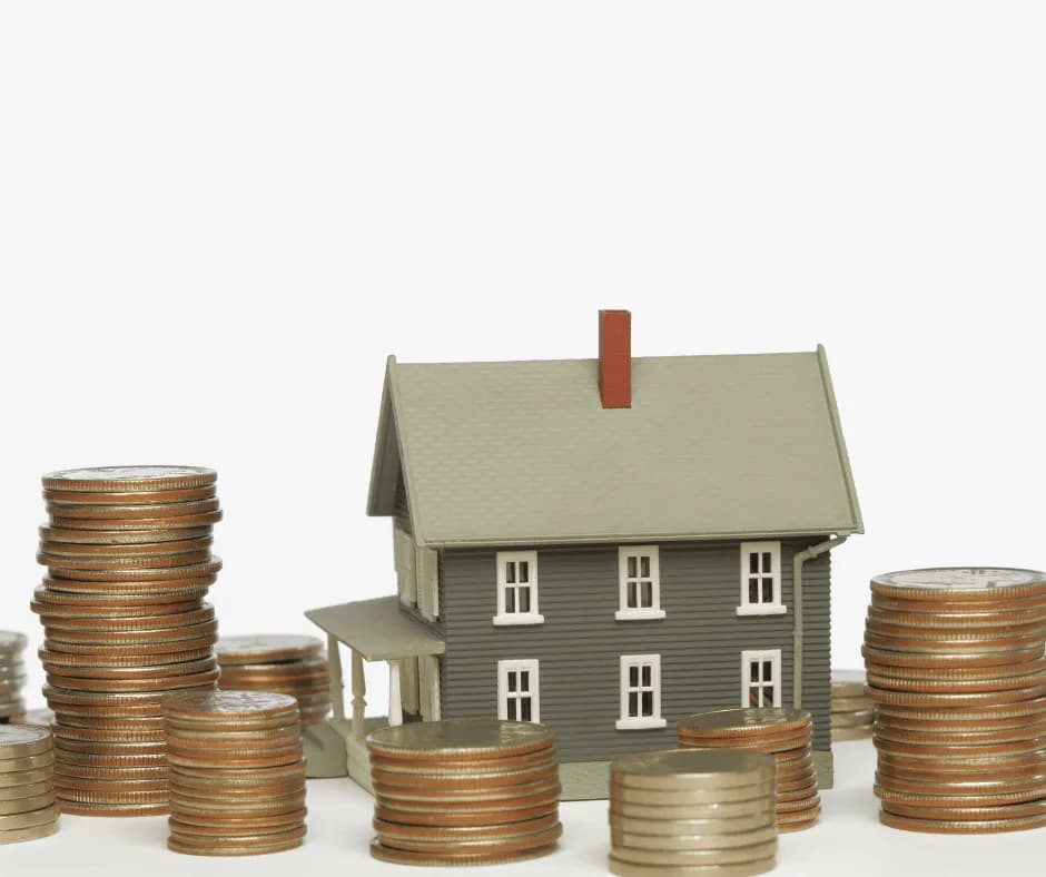 House model beside stacks of coins